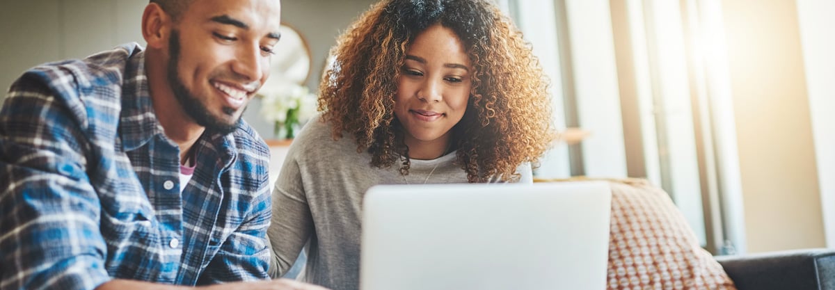 Couple at home looking at a laptop