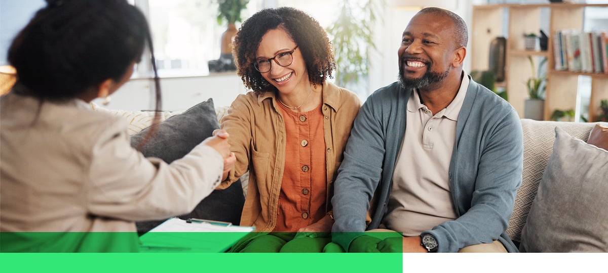 Happy couple finishing meeting with life insurance professional.